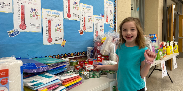 student places item on donation table