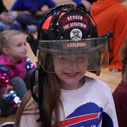 student with fire fighter helmet