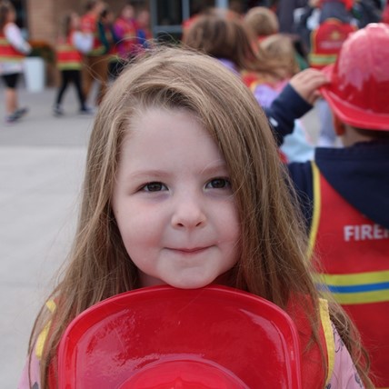 student with toy fire helmet