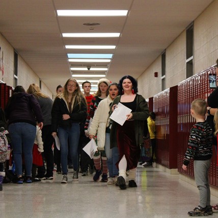 high school students carol at elementary school
