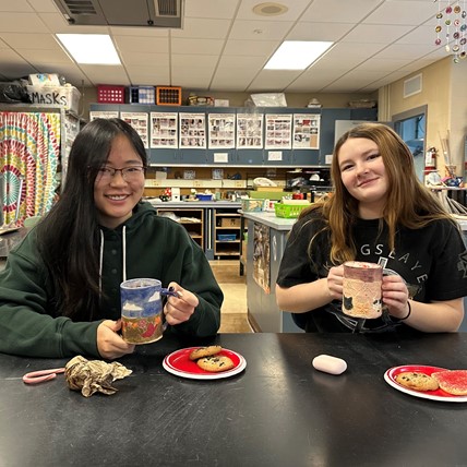 students show off handmade mugs
