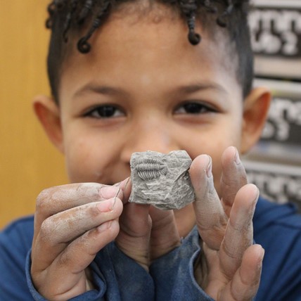students holds up fossil